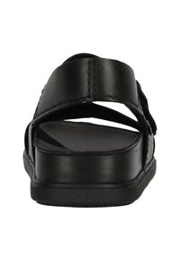 Czarne skórzane sandały z krzyżującymi się paskami, płaską podeszwą i gładką strukturą. Projekt jest minimalistyczny, bez widocznych akcentów.