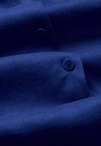 Tessuto blu navy con una texture liscia, dotato di due bottoni abbinati, che presenta un design semplice e pulito.
