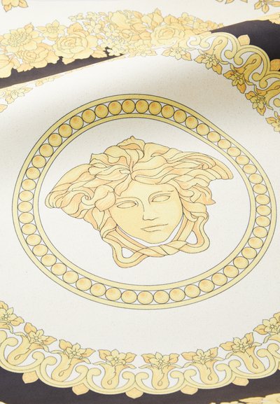 Dekorativní keramický talíř s centrálním motivem Medusy obklopeným složitými květinovými vzory ve zlaté, krémové a tmavě hnědé barvě.