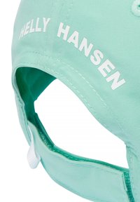 Gorra verde menta clara con el texto "Helly Hansen" en blanco, fabricada en un tejido suave, con una forma estructurada y correa ajustable en la parte posterior.