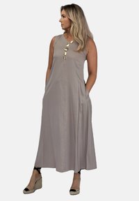 Sukienka bez rękawów, długa do ziemi, w miękkim taupe'owym materiale, z bocznymi kieszeniami, subtelnym kształtem A-linii oraz zdobnym złotym detalem przy dekolcie.
