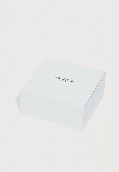 Scatola rettangolare bianca con superficie liscia, dettagli dorati lungo i bordi e la scritta "vanrycke PARIS" stampata in nero sulla parte superiore.