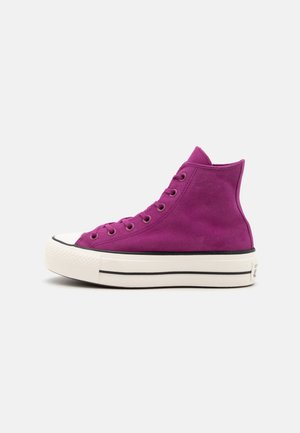 Zapatillas altas en ante púrpura vibrante con una suela de goma blanca y detalles en negro, que presentan cordones redondos y siete ojetes.