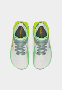 Ζευγάρι παπουτσιών για τρέξιμο σε μονοπάτι σε λευκό, γκρι και νέον πράσινο χρώμα, με γκρι κορδόνια, φωτογραφημένα από πάνω σε λευκό φόντο.