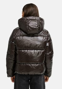 Puffjacka i mörkbrun, med en glänsande yta, stor huva och vadderad design med horisontella sektioner.