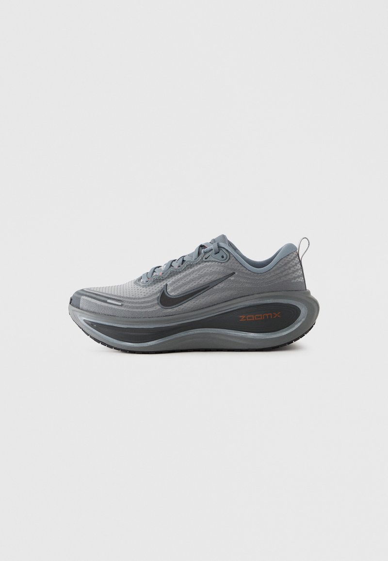 Chaussure de course Nike grise et noire avec semelle épaisse et amortie et étiquette "ZoomX" sur le côté, montrée de profil sur fond blanc.