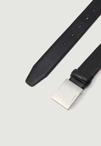 Curea din piele neagră cu un finisaj texturat, dotată cu o cataramă metalică dreptunghiulară argintie, gravată cu logo-ul "Calvin Klein".