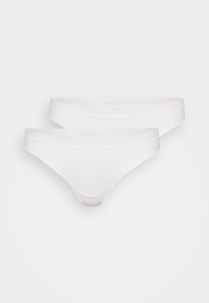 Weißer Tanga mit filigranem Spitzenbesatz am Bund. Glattes Material, das ein einfaches und minimalistisches Design zeigt. Zwei Teile enthalten.