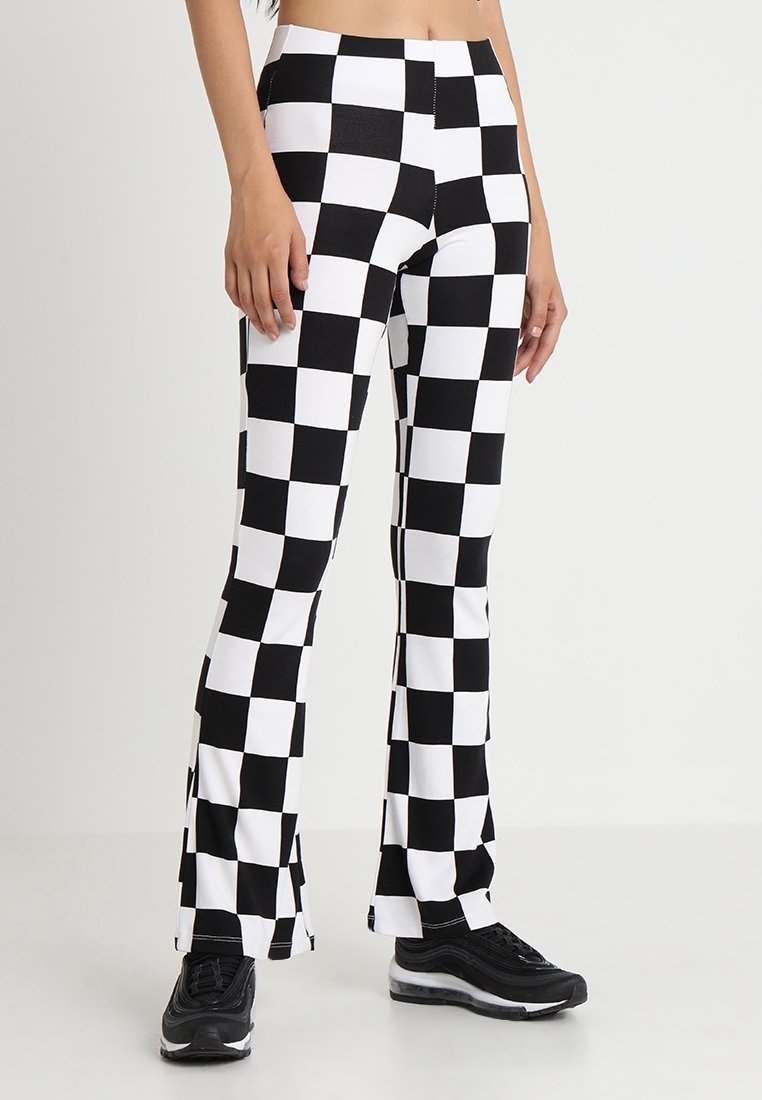 Black and white checkered flared leggings made of stretchy fabric, featuring a high waist and clean seams for a fitted look.