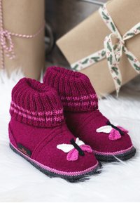 Flauschige Hausschuhe in tiefem Magenta mit gestrickten Bündchen, versehen mit Schmetterlingsapplikationen in Rosa und Weiß sowie strukturierten schwarzen Sohlen.