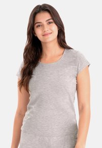 Camiseta gris de manga corta hecha de tela suave y texturizada con cuello redondo y ajuste holgado. Sin estampados ni detalles de herrajes visibles.