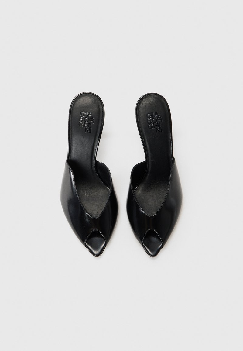 Schwarze Leder-Mules mit offener Zehenpartie, spitz zulaufender Form und ausgeschnittenem Oberteil. Glatte Textur und minimalistisch im Stil. Rutschfeste Ausführung ohne Verzierungen.