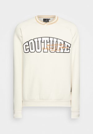 Cremiger Pullover mit Rundhalsausschnitt, ausgestattet mit auffälligem "COUTURE"-Schriftzug in Schwarz und Orange. Weicher Stoff, gerippte Bündchen und Saum.