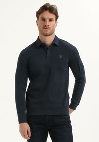 Marineblauw poloshirt met lange mouwen, gemaakt van een katoenmix, met een kraag, een knoopsluiting met drie knopen en een logo-opdruk op de borst.