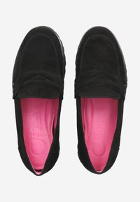 Mocassins en daim noirs avec un design à enfiler, dotés d'une semelle intérieure rose et d'une couture décorative sur le dessus. Forme à bout rond.