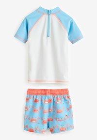 Maglietta a maniche corte da surf bianca e blu con zip sul retro. Pantaloni da bagno azzurri chiari con granchi rosa e vita elastica arancione.