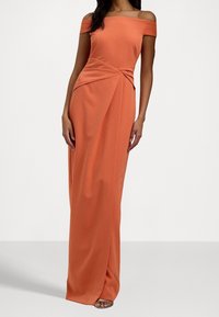 Orange av-axel klänning med en figurnära bodice, vriden detalj vid midjan och flytande drapering ner till golvet. Slät textur.