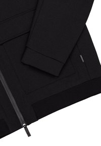 Czarna kurtka zapinana na zamek wykonana z gładkiego materiału. Ma wysoki kołnierz, ściągacze przy mankietach oraz kieszeń zapinaną na zamek z boku. Minimalistyczny design.