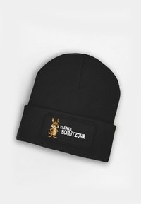 Black knitted beanie with a fold-over cuff, featuring a stitched black and brown patch displaying a cartoon rabbit and the text "KLEINES SCHLITZOOHR."