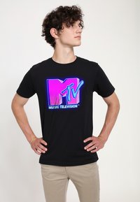 Černé bavlněné tričko s velkým barevným logem MTV v růžové a modré. Design je odvážný, s nápisem "MUSIC TELEVISION™" v bílé barvě.
