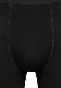 Boxer briefs de algodón negro con una textura suave, que presentan un ajuste estructurado, costuras visibles y una cinturilla para un uso seguro.