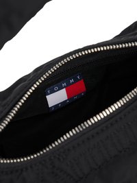 Fekete szövet bevásárlótáska ezüst cipzárral. Belsejében Tommy Jeans címke található kék, vörös és fehér blokk színekkel. Simább textúrával.