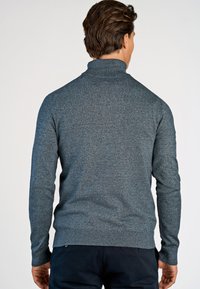 Szary sweter z golfem, dziany, z prążkowanymi mankietami i dołem, charakteryzujący się teksturowanym wykończeniem oraz dopasowanym krojem, oglądany z tyłu.