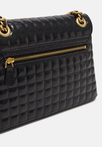 Sac à main noir matelassé au design classique en forme de boîte, texture brillante, accents en métal doré, et une poche zippée à l'avant.