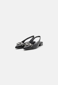Black patent leather slingback shoes with a pointed toe, accented by a silver chain detail. Low block heel and open back design.
