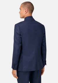 Chaqueta de traje a rayas finas azul marino con un corte entallado, solapas de muesca y puños abotonados, con un acabado de textura suave.