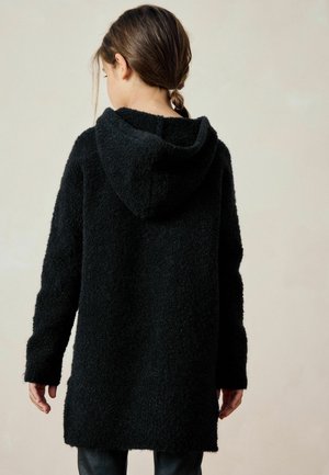 Hoodie nero in peluche con una finitura morbida e testurizzata, maniche lunghe e un fit rilassato, con vista posteriore e orlo leggermente affondato.