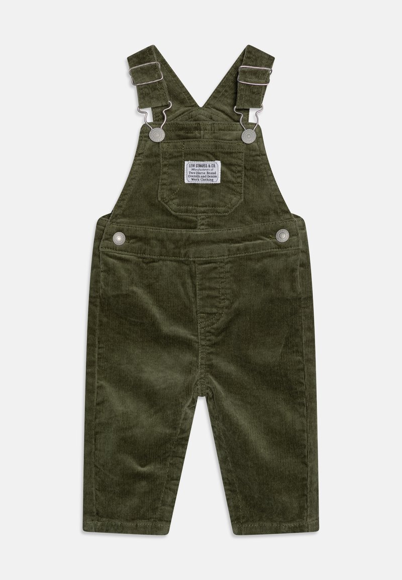 Pantalones de peto de pana en verde oliva con tirantes ajustables, botones de presión metálicos y un bolsillo frontal con una etiqueta de la marca.