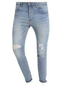 Vaaleansiniset farkut tiukkaa mallia, joissa on kuluneet polvipaikat, haalistunut väri, viisi taskua ja raikkaat, harottavat lahkeet.