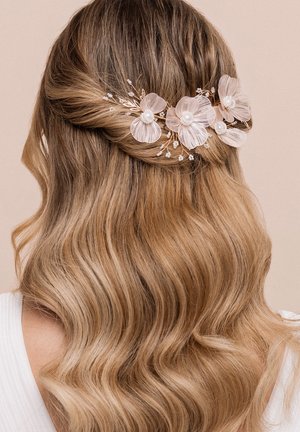 Accessorio per capelli con filo in oro rosa, dettagli floreali traslucidi e perle finte, posizionato in capelli lunghi e mossi su uno sfondo neutro.