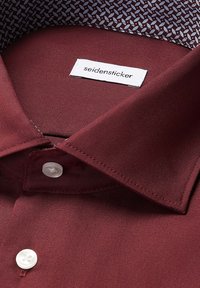 Bordeauxhemd met een gladde textuur, witte knopen en een patroon aan de binnenkraag. Etiket zegt "seidensticker."