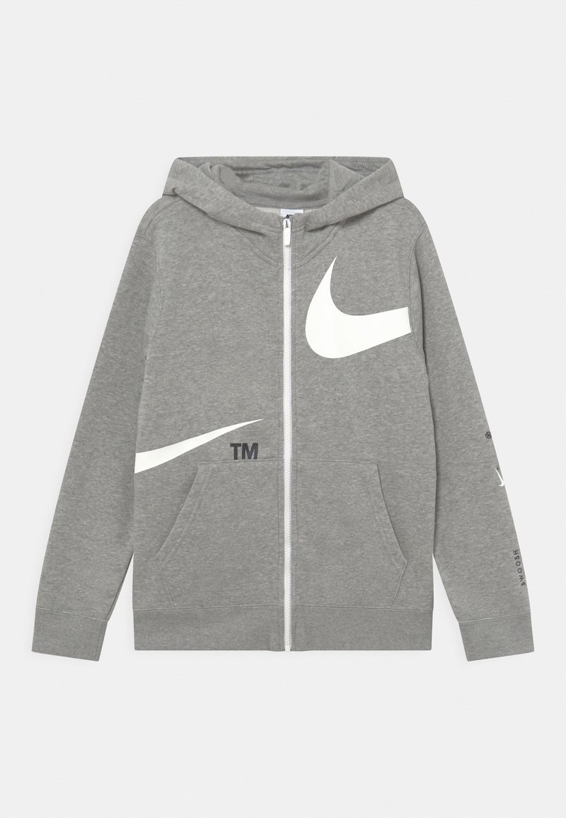 Un sweat à capuche zippé gris en tissu doux, doté de logos Nike swoosh blancs sur le devant et les manches, avec des poches latérales et une capuche.