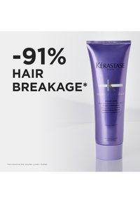 Kérastase Blond Absolu Cicaflash-behandling i et fiolett rør, med en glatt tekstur og pumpehette. Teksten viser "-91 % HÅRBRUDD."