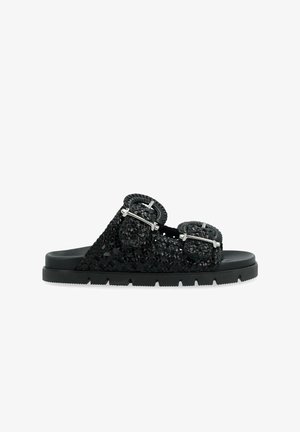 Las sandalias negras cuentan con un upper texturizado y tejido, con dos hebillas decorativas y una suela de goma para mayor tracción. Diseño ligero y abierto.