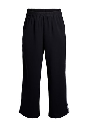 Mustat kuminauhavyötäröllä varustetut verkkahousut, joissa on väljät lahkeet ja valkoiset sivuraidat valkoisella taustalla.