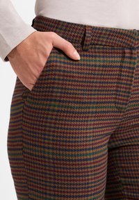 Broek met een meerkleurig houndstoothpatroon in bruin, groen en paars, met een gladde textuur en zijzakken.