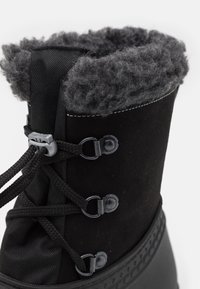 Černé zimní boty s texturovaným svrškem, kožíškem na horním okraji a vyztuženými očky pro šňůrky. Gumová podrážka pro dlouhou životnost.