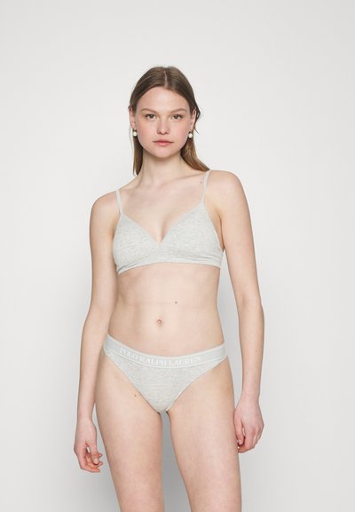 Bralette gris con tirantes finos y forma triangular, combinado con un tanga gris a juego que presenta una cinturilla con logo. Textura de tela suave.