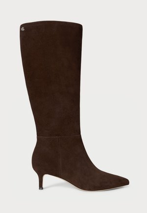 Brune semskede kne-høye støvler med spiss tå og kitten heels. Har en glatt tekstur og en subtil logo detalj på skaftet.