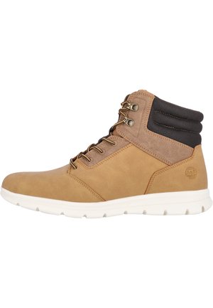 Bottes mi-hautes en cuir marron avec semelles blanches, œillets en métal et un col en tissu noir texturé pour un soutien supplémentaire.