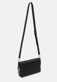 Schwarze Umhängetasche aus strukturiertem Leder, mit einem langen, verstellbaren Tragegurt und silberfarbenen Beschlägen sowie einem dekorativen Anhänger.