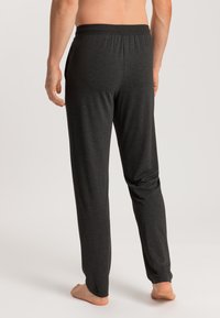 Zwarte heren loungebroeken met een relaxte pasvorm, elastische tailleband en een zachte, gladde textuur. Heeft geen zichtbare patronen of hardware-accenten.