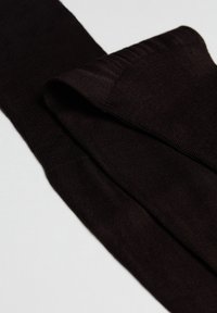 Tessuto in maglia nera, piegato con una trama liscia. Presenta un motivo uniforme e bordi a coste. Forma compatta e slanciata.
