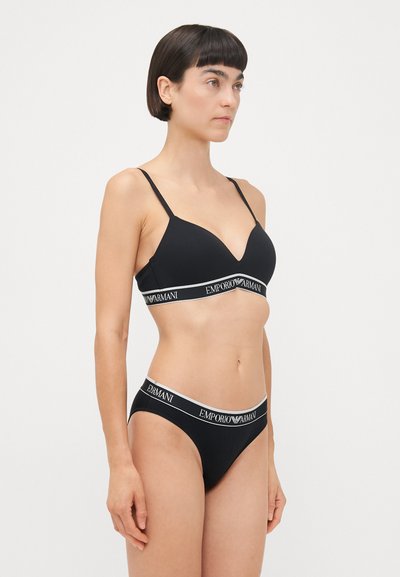 Zwarte bh en bikiniset met dunne bandjes, een V-hals ontwerp en gemerkte elastische taillebanden met "Emporio Armani" in het wit.