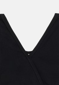 Κοντινή λήψη μαύρου υφάσματος που δείχνει λαιμόκοψη σε σχήμα V με διπλές ραφές σε ένδυμα.