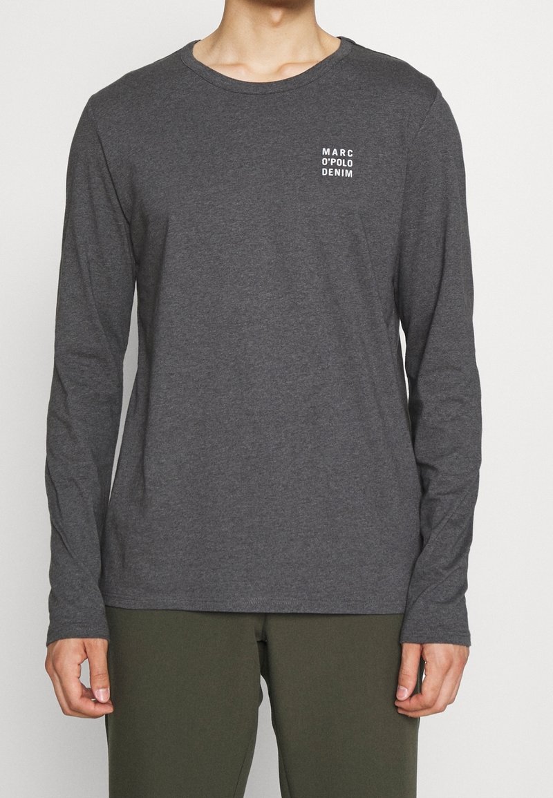 Langärmliges graues T-Shirt aus weicher Baumwolle mit Rundhalsausschnitt und einem kleinen weißen Logo auf der linken Brustseite.